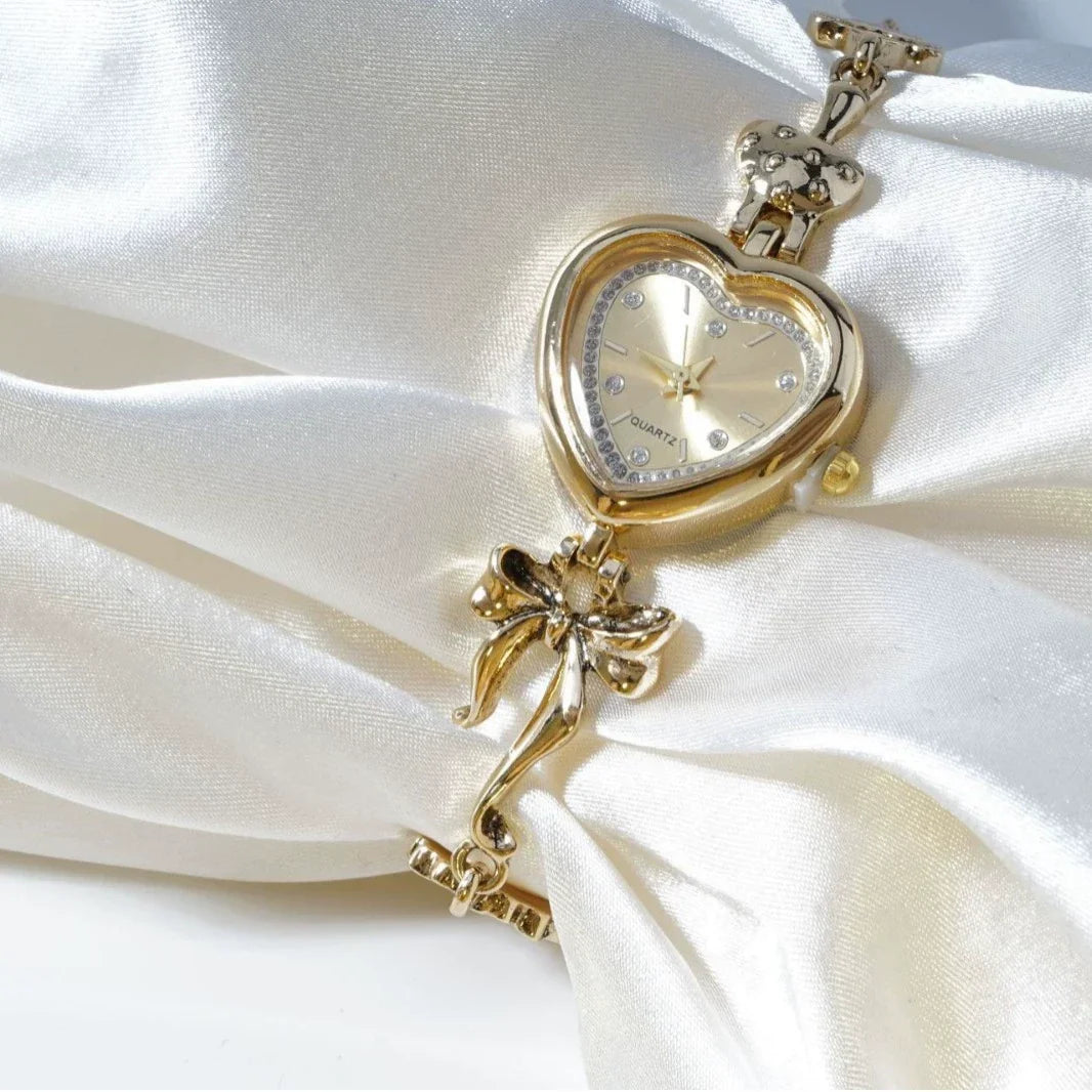 Heart Case Bracelet Watch — Gold-Tone, Crystal Bezel, Champagne Dial & Bow Charm Chain, Women